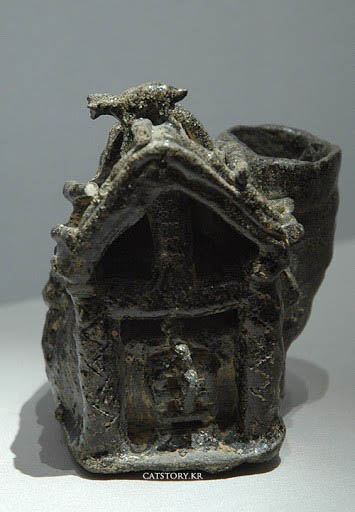 가야 상형 토기 유물은 고양이와 관련한 가장 오래된 유물이다. 지붕 위 고양이가 아래 쥐를 노리고 있는 모습이 있다. 집은 생활공간이자 곡식을 저장하는 곳으로 쥐 떼가 들끓었다. 애초 고양이는 쥐를 잡는 역할로 인간의 영역으로 들어왔다. 이전에는 살쾡이나 족제비 따위가 쥐를 잡았지만, 인간과의 교감 능력이 떨어져 밀려났다. 그렇다고 고양이가 가축이 된 것은 아니다. 여담이지만, 어떤 학자는 사람이 고양이를 선택한 것이 아니라 고양이가 사람을 선택하여 길들였다고 말한다. [사진 제공 - 심규섭]