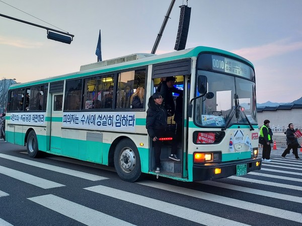 내란수괴 지금 당장 파면하라. 피의자는 수사에 성실히 임하라는 구호를 붙이고 행진 대열을 뒤따라 가는 버스. [사진-통일뉴스 이승현 기자]