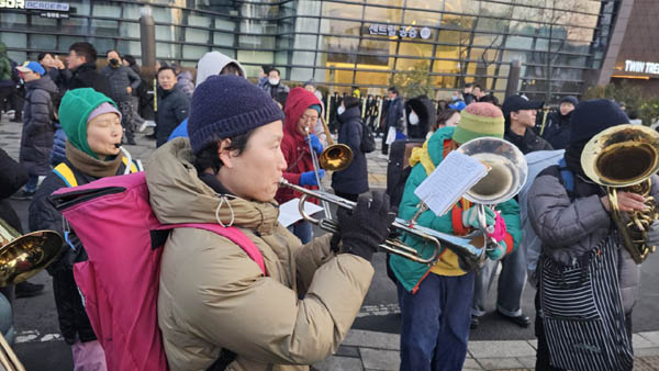 보도에서 연주로 응원을 보내고 있다. [사진 - 하태한 통일뉴스 통신원]