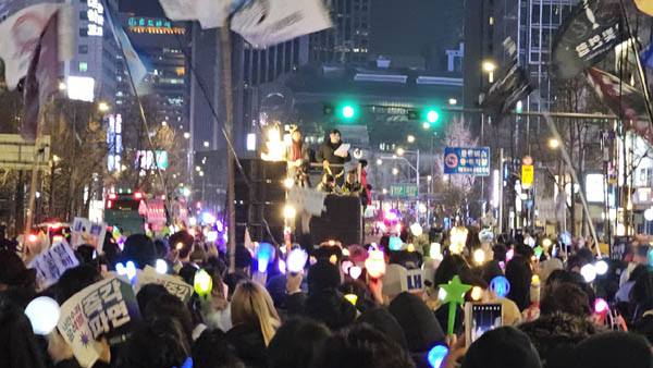 응원봉을 흔들며 행진하고 있다. [사진 - 하태한 통일뉴스 통신원]