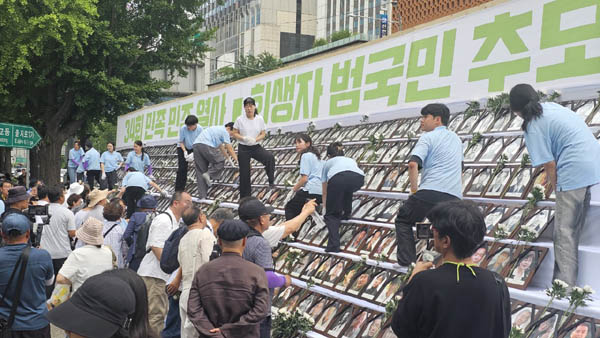 개별 영정에 꽃을 달아주고 있다. [사진 - 통일뉴스 하태한 통신원]