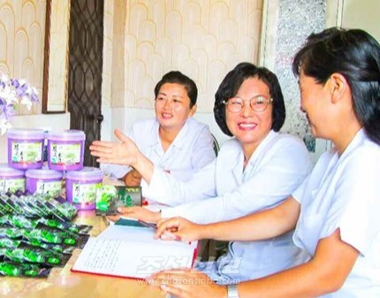 북한 약동건강제품생산소에서 개발한 검은소금은 고혈압과 뇌혈전, 당뇨병, 비만 등을 예방할 수 있는 건강제품이라고 한다. 이 '검은소금'의 개발자인 김혜영씨(가운데). [사진-조선신보 갈무리]