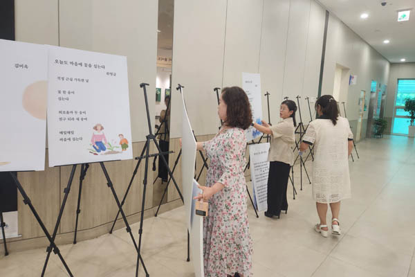 행복여정문학 회원들이 설치 작업을 진행하고 있다. [사진 - 통일뉴스 위영금 통신원]