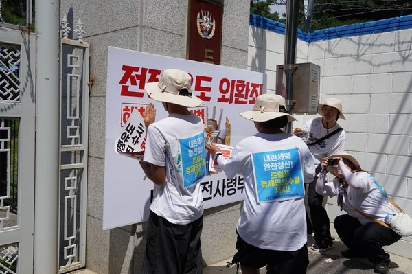 26일 포천시 노곡2리 투쟁위원회와 시민·19기 서울지역자주통일평화선봉대·인천지역통일일선봉대가 포천시 드론사령부 입구 현판에 전쟁 유도 외환죄 ′처벌·해체′ 손피켓 붙이기 퍼포먼스 장면. [사진-통일뉴스 위정량 통신원]