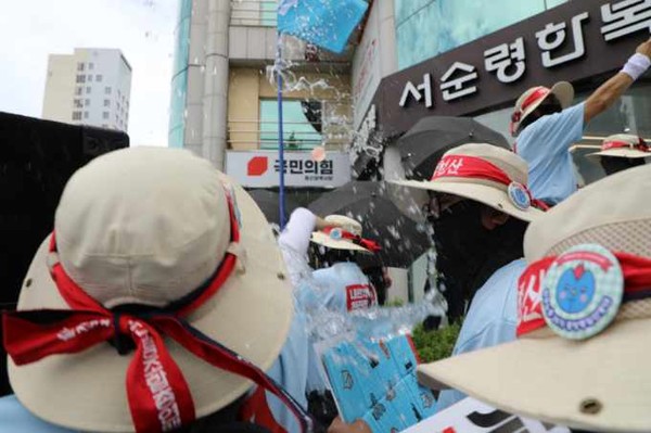 민주노총 26기 중앙통일선봉대가 11일 울산에서 노조법 2·3조 개정을 거부하는 국민의힘 울산시당사를 향하여 물폭탄을 던지는 규탄투쟁을 전개하고 있다. [사진제공-민주노총 중앙통일선봉대]