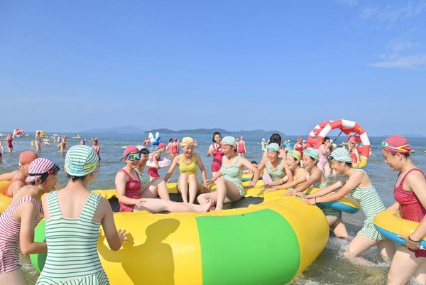 대형 튜브에서 노는 여자 원아들. [사진-노동신문 갈무리]