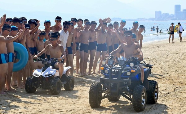 모래장에서 오토바이를 타는 원아들. [사진-노동신문 갈무리]