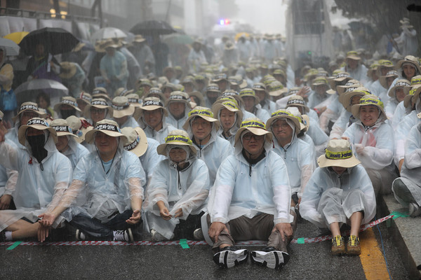 쏟아지는 폭우속에서 일본군 위안부 문제해결을 위한 수요시위를 사수하고 있는 민주노총 26기 중앙통일선봉대. [사진-민주노총 중앙통일선봉대]