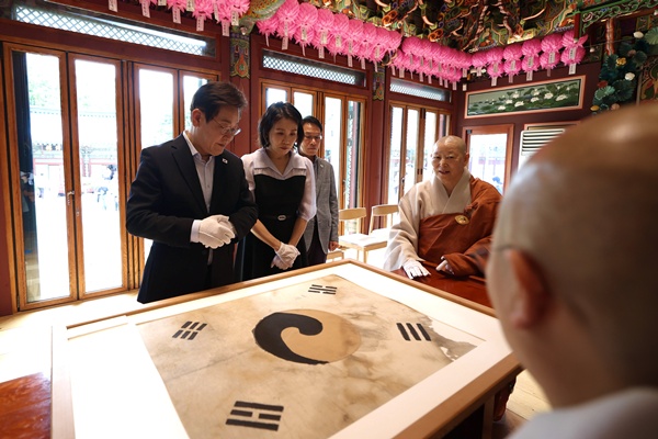 서울 은평구에 있는 진관사를 찾아 '태극기'를 살펴보는 이 대통령 부부. [사진-대통령실]