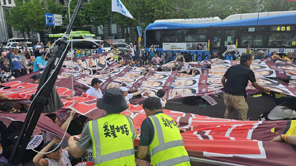 국민의힘 해산 포퍼먼스. 투표불참 의원 사진을 찢고 있다. [사진 - 통일뉴스 하태한 통신원]