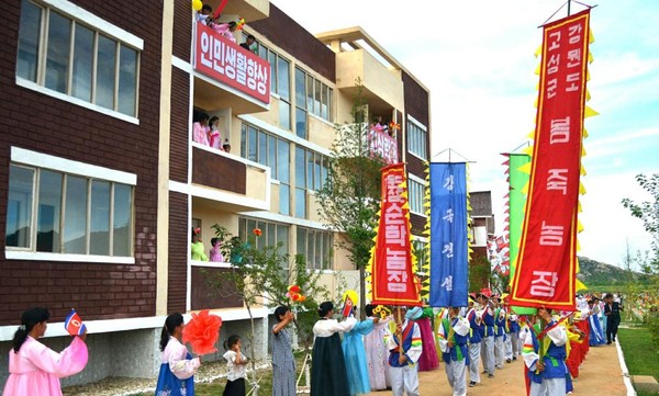 흥겨운 농악무와 축하공연무대가 펼쳐진 새집들이 행사. [사진-노동신문 갈무리]