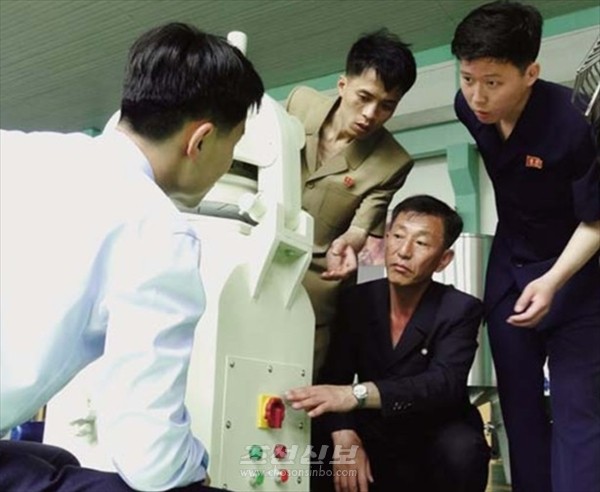 빵생산 설비들을 제작한 평양기계대학의 교원, 연구사들.[사진-조선신보 갈무리]