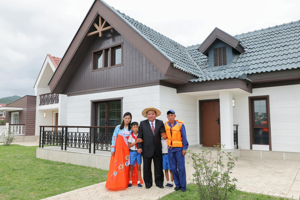 김 위원장이 낙원군 새 살림집 입주자들과 기념촬영을 하고 있다. [사진-노동신문] 
