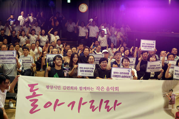 ‘평양시민 김련희와 함께하는 작은 음악회’ 전체 참가자들이 ‘돌아가리라’는 주제 펼침막을 들고 기념사진을 남겼다. [사진 – 통일뉴스 김래곤 통신원]