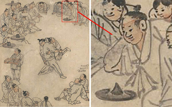 씨름판의 설계자이자 운영자이다. 덩치가 크고 맨상투를 하고 있다. 전립을 벗어 앞에 놓았다. 일반 갓과 다르다. 김홍도가 설계자를 특정하기 위해 배치했다. [사진 제공 - 심규섭]