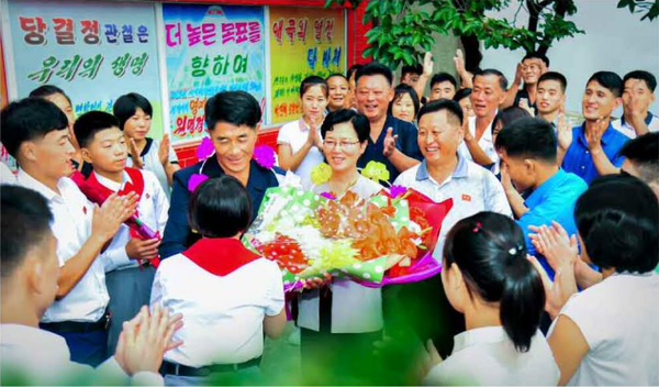 2025년 세계레슬링선수권대회 금메달리스트인 원명경선수의 부모가 축하를 받고 있다. [사진-노동신문]