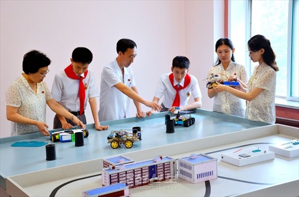 정보화의 모범단위로 알려져 있는 모란봉제1중학교의 교원과 학생들이 실험연습을 하고 있다. [사진-조선신보 갈무리]