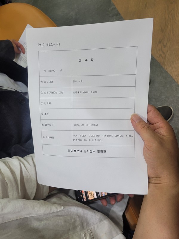 국가보안법 피해자 신동훈 대표가 항의서한 접수증을 국정원 직원으로부터 건네 받았다. [사진-통일뉴스 김래곤 기자]