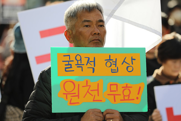 대회 참가자가 굴욕적 협상 원천무효! 라는 손팻말을 들고 행진하고 있다. [사진-통일뉴스 김래곤 통신원]