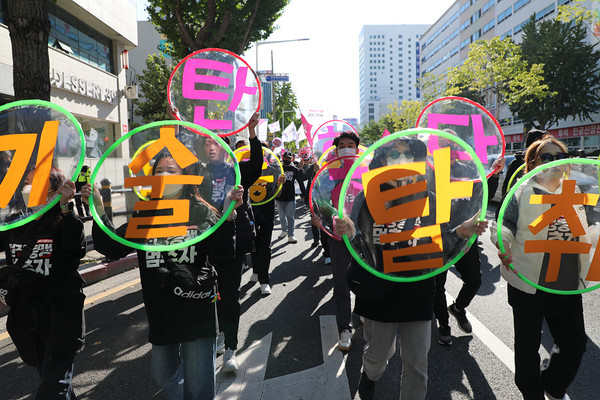 대회 참가자들이 미국의 ‘기술 탈취’ 등 횡포를 비난하는 원형 투명 패널을 들고 행진하고 있다.  [사진-통일뉴스 김래곤 통신원]