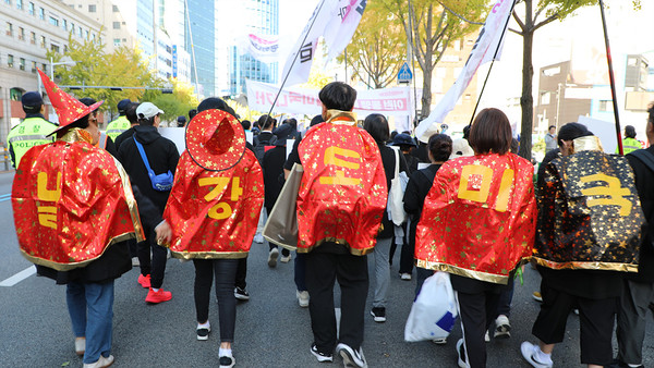 대회 참가자들이 ‘날강도 미국’이라는 문구가 새겨진 화려한 망토를 입고 행진하고 있다.  [사진-통일뉴스 김래곤 통신원]