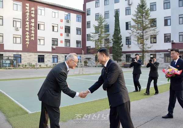 노동신문사 백룡 부주필이 노동신문사 청사 안마당에서 재일 총련 조선신보사 대표단 성원들을 맞이하고 있다. [사진-조선신보 갈무리]