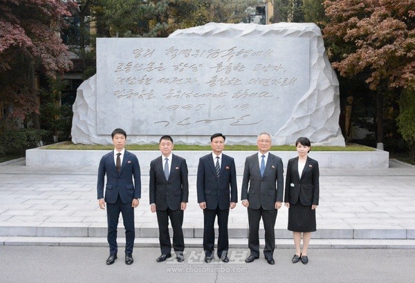 재일 조선신보사 대표단이 노동신문사를 방문해, 김정일 국방위원장의 친필비 앞에서 기념사진을 남겼다. [사진-조선신보 갈무리]