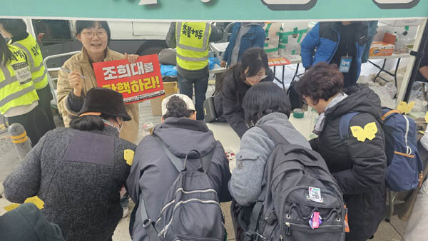 자원봉사자의 부스에서 조희대 수사를 촉구하는 서명대에도 시민들이 많았다. [사진 - 통일뉴스 하태한 통신원]