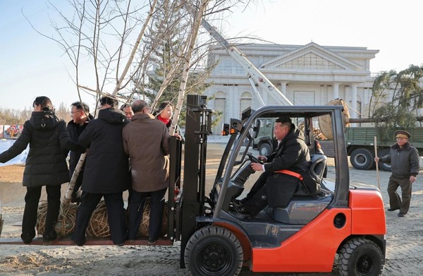 김 위원장이 직접 지게차를 운전하고 딸과 함께 나무를 심는 사진이 10여 장 게재되었다. [사진-노동신문]