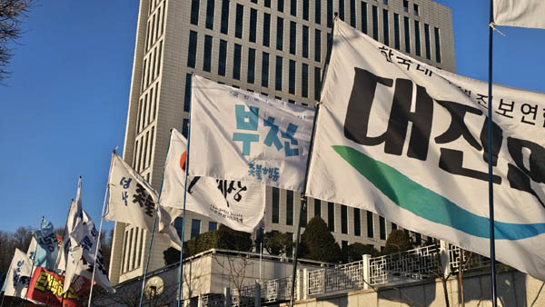 촛불대행진에 참여한 단체들의 깃발 뒷편으로 대법원이 보인다. [사진 - 통일뉴스 하태한 통신원]