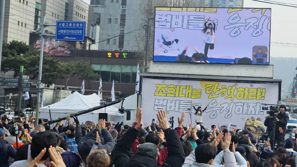 마포은평서대문 촛불행동의 최은비 님은 집회시민 모두가 일어서서 함께하는 몸풀기 체조로 활력을 불어 넣었다. [사진 - 통일뉴스 하태한 통신원]