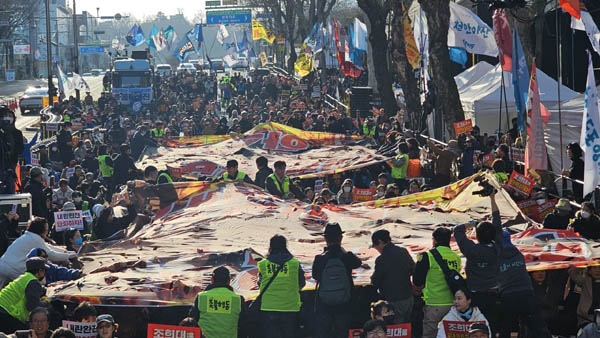 상징의식 퍼포먼스로 내란공범 조희대와 내란세력 하수인 지귀연의 걸개그림을 시민들이 찢는 행위예술을 진행했다.  [사진 - 통일뉴스 하태한 통신원]