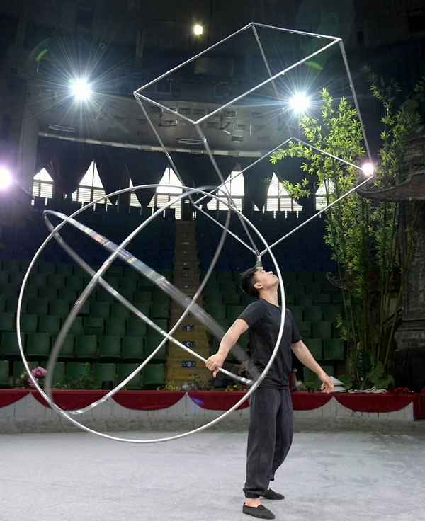 교예연맹교예단의 한 배우가 원구 모형과 정육면체 모형의 기구로 연습 중에 있다. [사진-노동신문 갈무리]