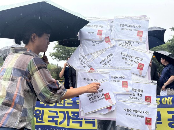 국가정보원의 국가폭력 사건과 관련한 자료를 빈 포스터에 붙이는 퍼포먼스가 진행됐다. [사진-통일뉴스 서영빈 기자]